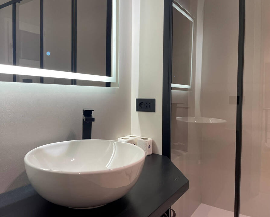 Bright, sleek, and spotless—a modern bathroom with quality fittings and a walk-in shower. Modern bathroom in Olbia holiday townhouse with walk-in shower, elegant tiles, and premium fittings