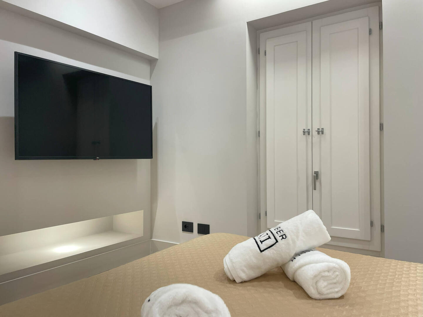 2 master bedrooms with shutters and large TVs.